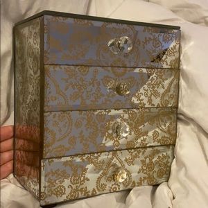 A mirror jewelry box with four drawers.